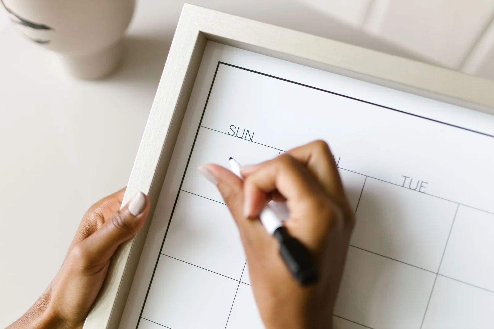 Calendrier de déménagement posé sur une table avec des cartons empilés derrière