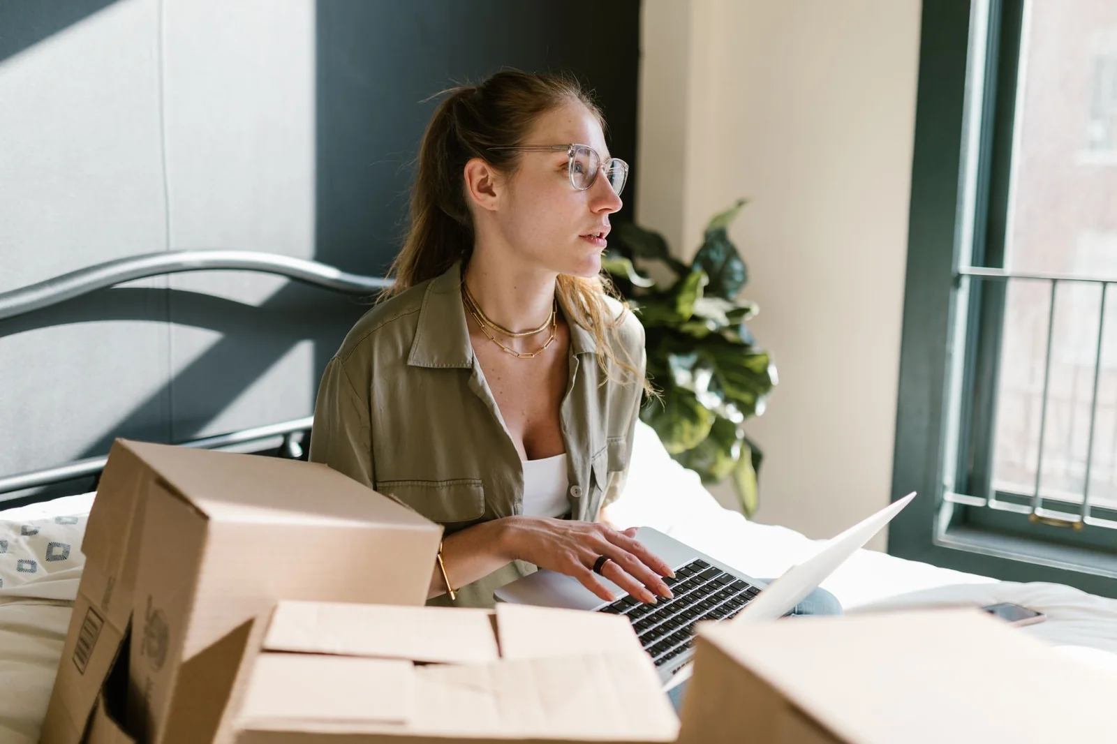Ordinateur portable ouvert sur une démarche administrative en ligne, avec des cartons en arrière-plan